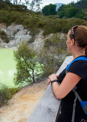 Image of a geothermal lake with someone standing next to the fence