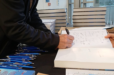 Image of someone signing a book
