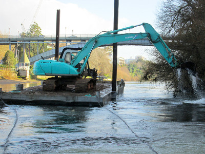 Digger on the back of the floating platform under the iconic Anzac Parade bridge in Hamilton.